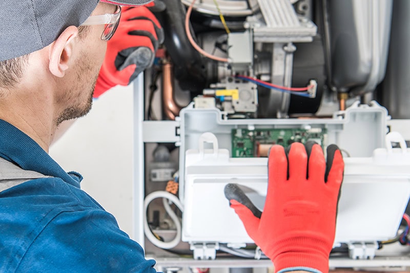 How Can I Make My Furnace Last Longer? A technician working on a furnace.